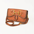 Brown leather crossbody bag with antique-finish equestrian bit hardware and decorative rivets.