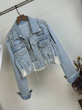 Blue cropped denim jacket with metal studs, chest pockets and distressed hem