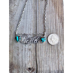 Wild double-heart pendant close-up with coin shown for scale