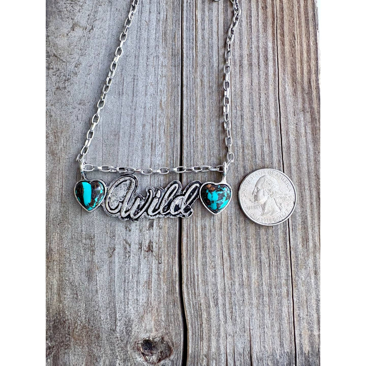 Wild double-heart pendant close-up with coin shown for scale